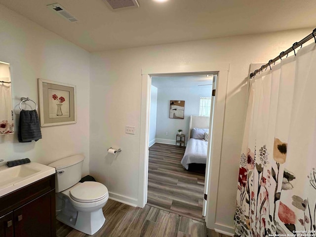 bathroom with vanity, toilet, and hardwood / wood-style flooring