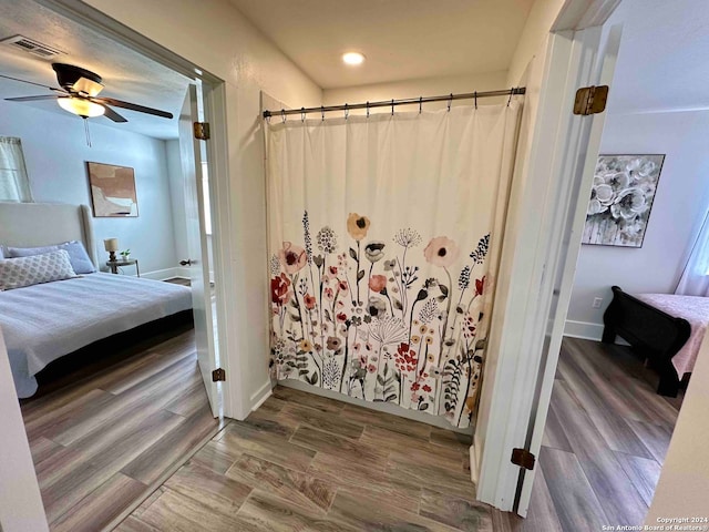 bathroom with hardwood / wood-style floors and ceiling fan