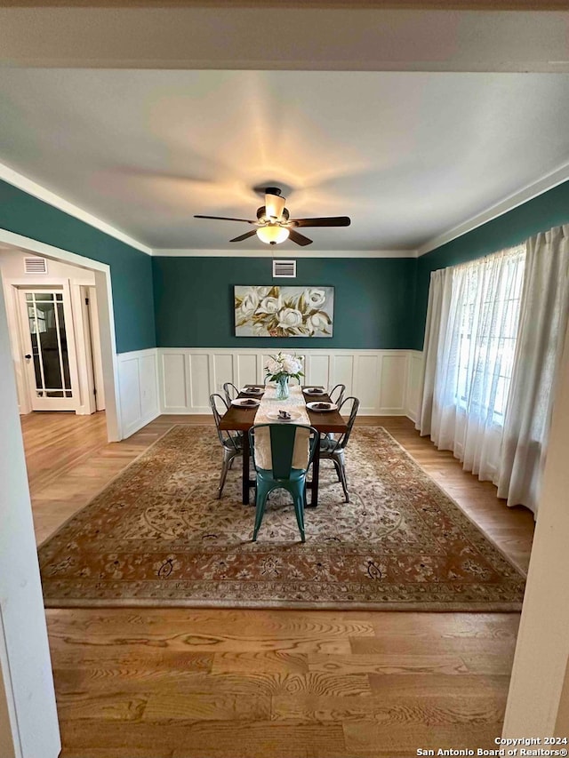 dining space featuring light hardwood / wood-style flooring, ornamental molding, and ceiling fan