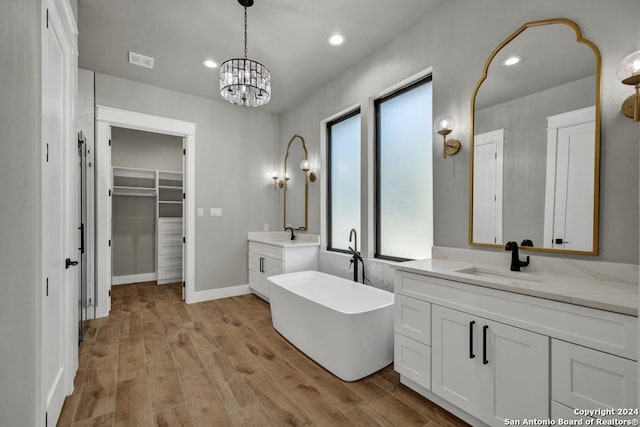 bathroom with vanity, wood-type flooring, and a tub