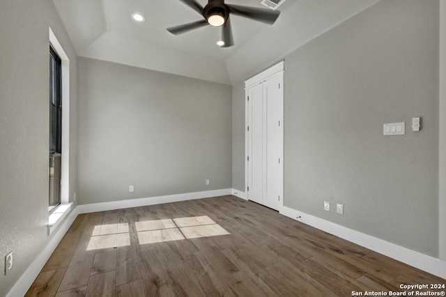 unfurnished bedroom with hardwood / wood-style flooring, ceiling fan, lofted ceiling, and a closet