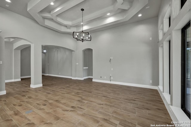 unfurnished room featuring an inviting chandelier and a high ceiling