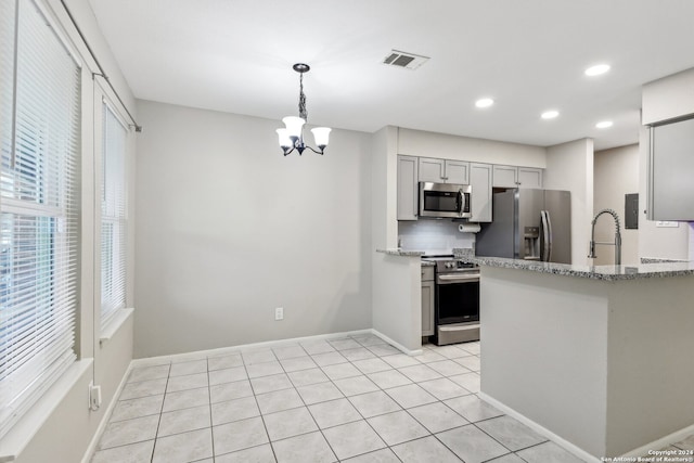 kitchen featuring gray cabinets, a notable chandelier, light stone counters, appliances with stainless steel finishes, and light tile patterned floors