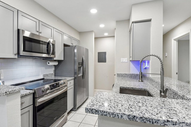 14343 Judson Rd Unit 803, San Antonio, TX 78233 - kitchen featuring stainless steel appliances, a sink, backsplash, light stone counters, and light tile patterned flooring