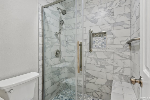 bathroom with an enclosed shower and toilet