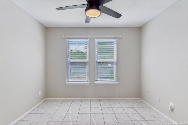 empty room featuring a healthy amount of sunlight, light tile patterned floors, and ceiling fan