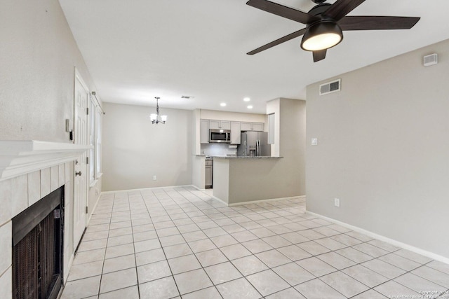 14343 Judson Rd Unit 803, San Antonio, TX 78233 - unfurnished living room featuring ceiling fan, a chandelier, a tiled fireplace, baseboards, and recessed lighting