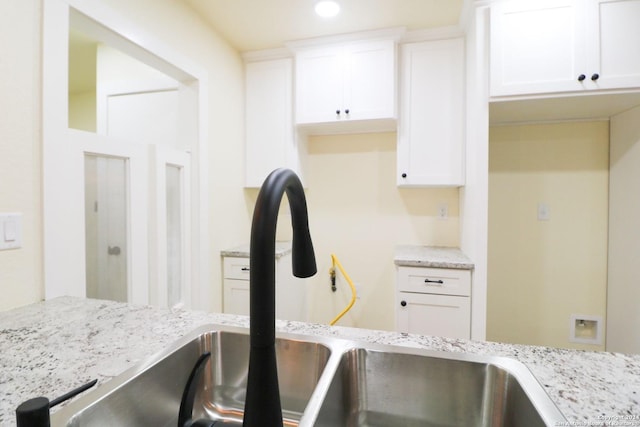 kitchen featuring white cabinets and light stone counters