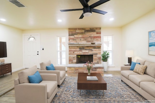 living room featuring ceiling fan, dark hardwood / wood-style flooring, and a fireplace