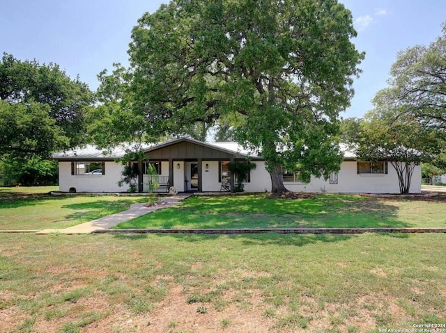 ranch-style house with a front yard and a porch