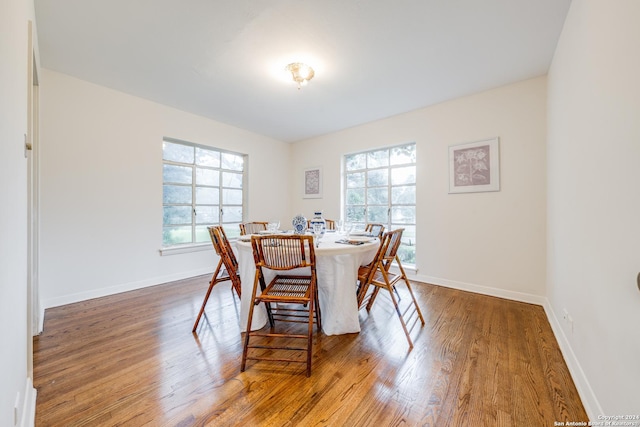 dining area with dark wood-type flooring and a wealth of natural light