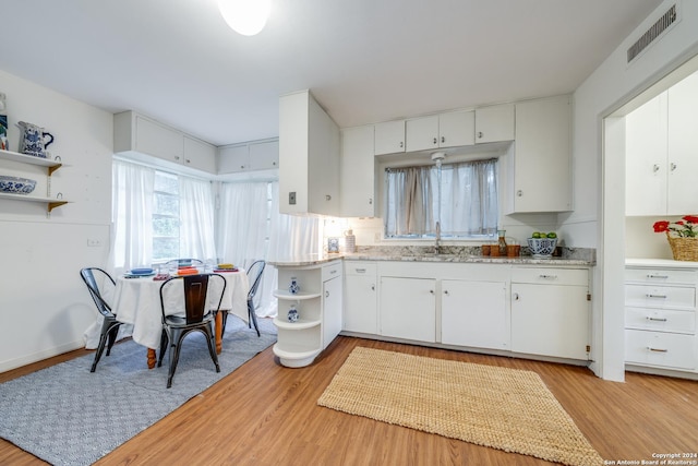 kitchen featuring sink, light hardwood / wood-style flooring, and white cabinets