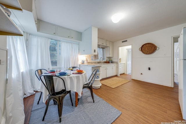 dining space with sink and light hardwood / wood-style flooring