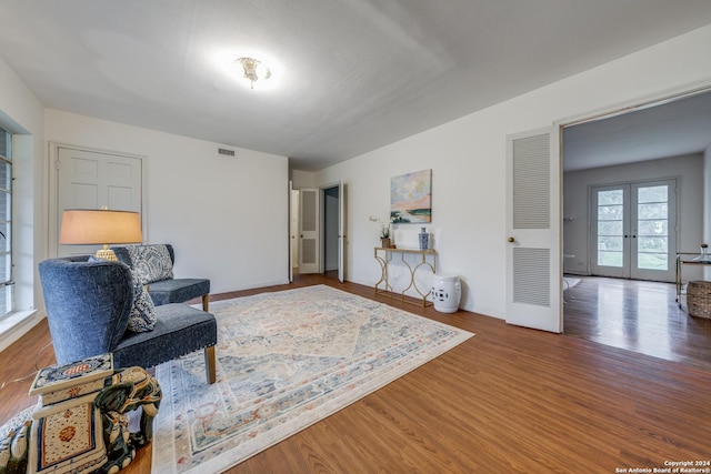 living area with hardwood / wood-style flooring and french doors