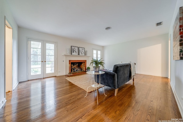 living room featuring a healthy amount of sunlight, light hardwood / wood-style floors, and french doors