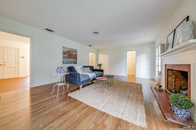 living room with light hardwood / wood-style floors and a tile fireplace