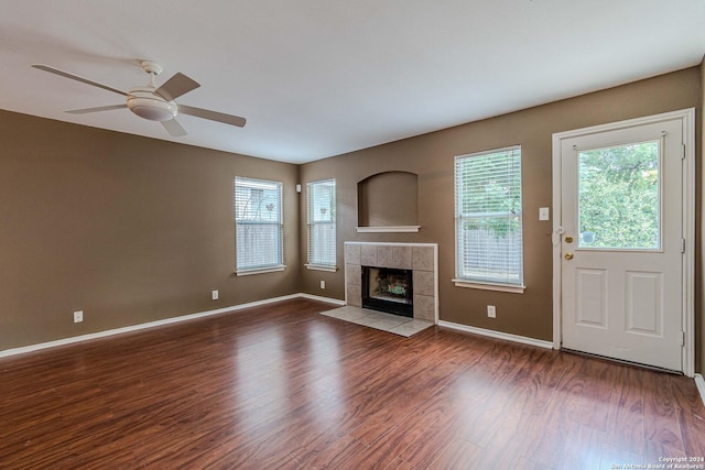 unfurnished living room with ceiling fan, hardwood / wood-style flooring, and a tile fireplace