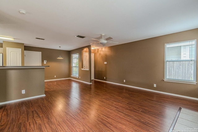 unfurnished living room with dark wood-type flooring and ceiling fan