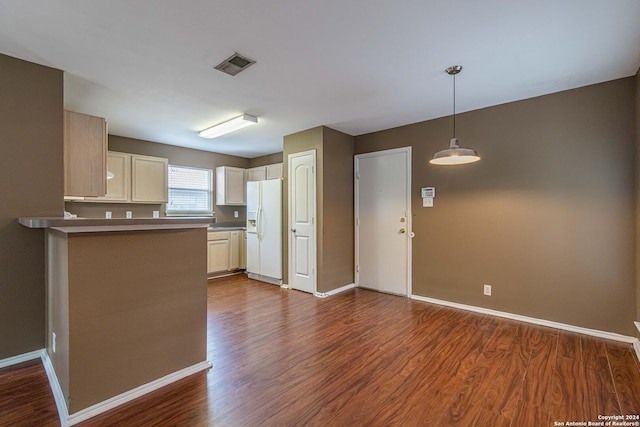 kitchen with decorative light fixtures, white fridge with ice dispenser, dark hardwood / wood-style flooring, and kitchen peninsula