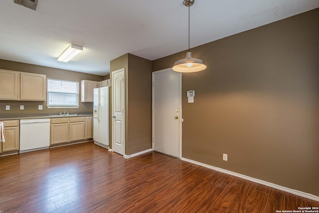 kitchen with sink, white appliances, dark hardwood / wood-style flooring, and hanging light fixtures