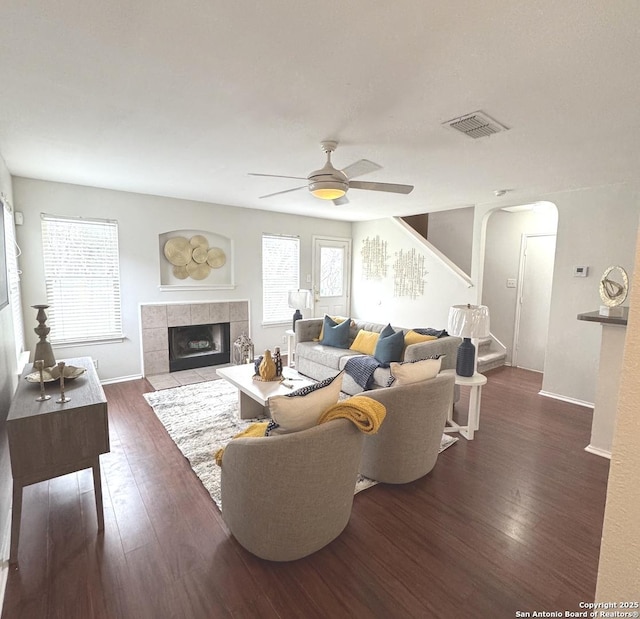 living room with dark wood-type flooring, a fireplace, and plenty of natural light