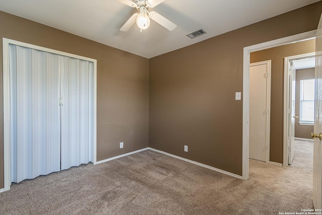 unfurnished bedroom featuring ceiling fan, a closet, and light carpet