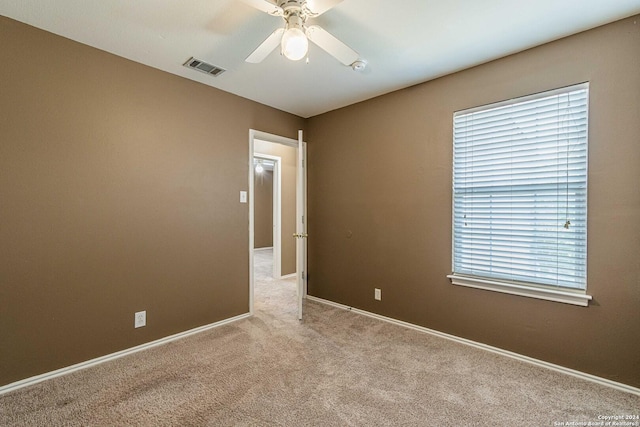 carpeted spare room featuring ceiling fan