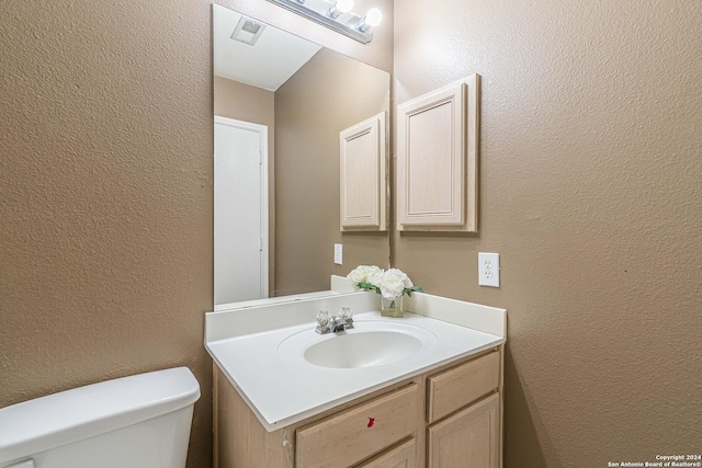 bathroom with toilet and vanity