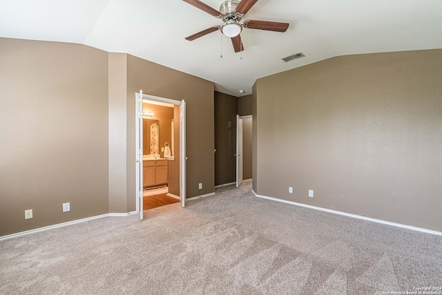 unfurnished bedroom with lofted ceiling, ceiling fan, light carpet, and connected bathroom