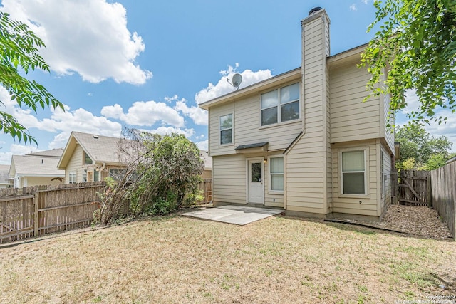 back of property with a patio area and a lawn