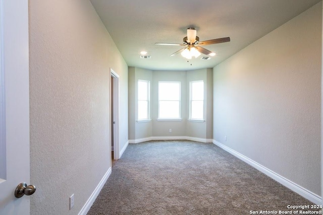 empty room featuring ceiling fan and carpet flooring