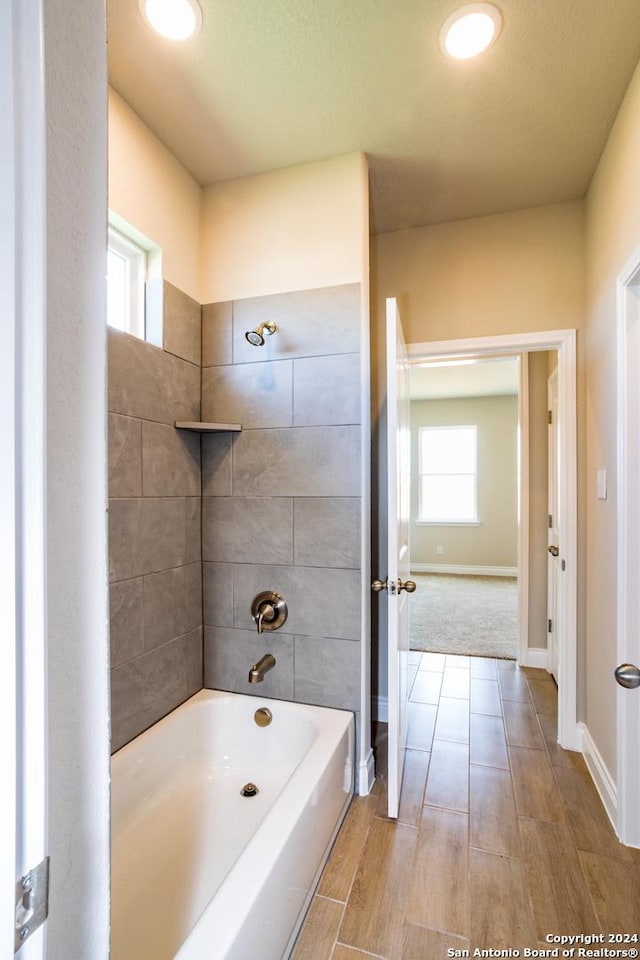 bathroom featuring tiled shower / bath combo and a wealth of natural light