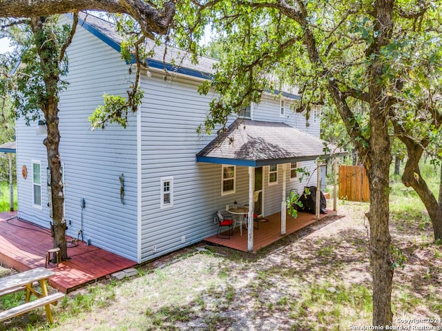 back of property with fence and a deck