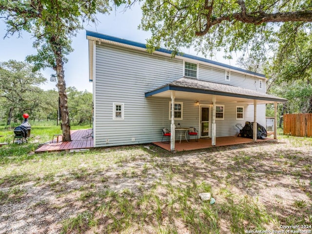 rear view of property with fence and a wooden deck