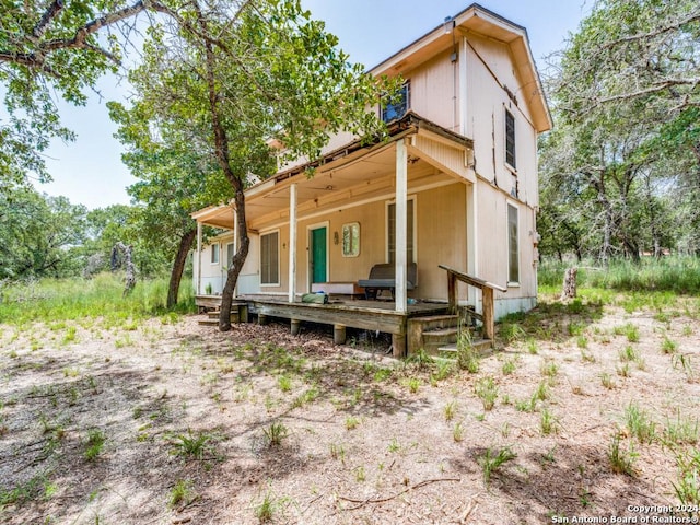 back of property with covered porch