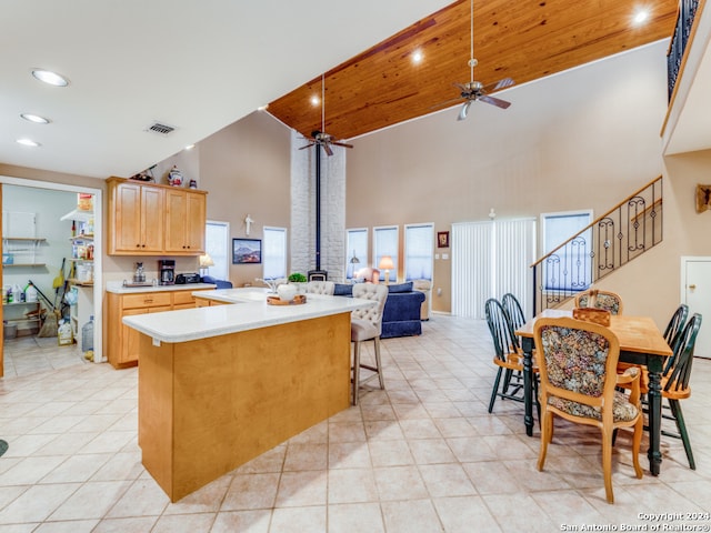 kitchen featuring ceiling fan, light brown cabinets, light tile patterned floors, and high vaulted ceiling