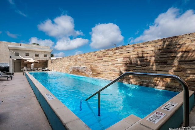 view of pool with pool water feature and a patio