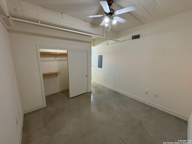 unfurnished bedroom featuring concrete floors, electric panel, a closet, and ceiling fan