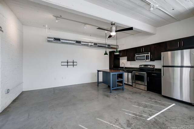 kitchen with a breakfast bar area, stainless steel appliances, wood counters, sink, and dark brown cabinets