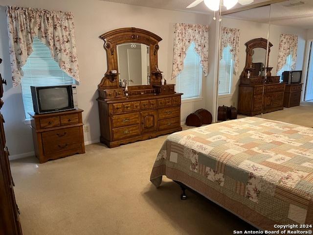 bedroom with ceiling fan and light colored carpet