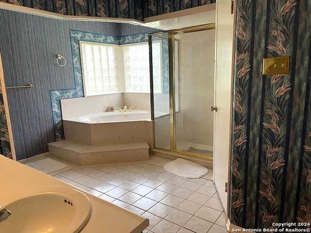 bathroom featuring tile patterned flooring, independent shower and bath, and sink