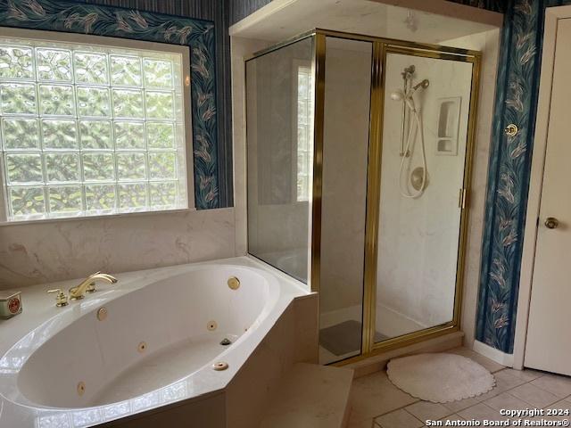 bathroom with tile patterned flooring and plus walk in shower