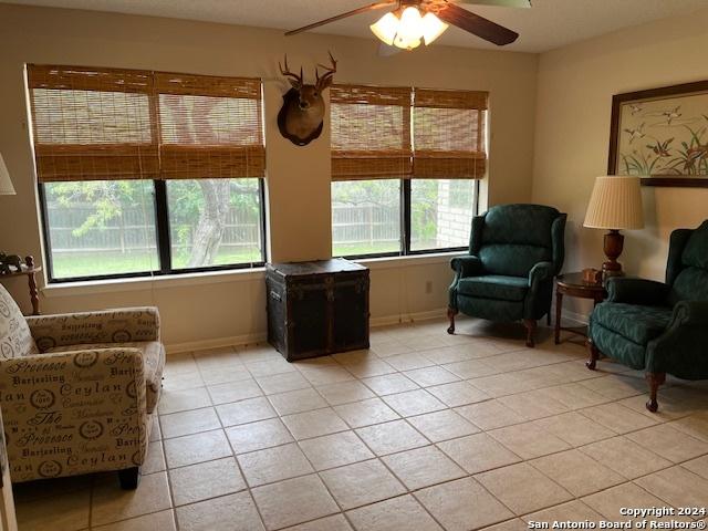 sitting room featuring ceiling fan and light tile patterned flooring