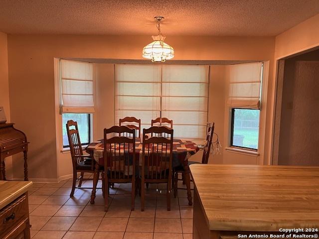 dining space featuring light tile patterned floors and a textured ceiling