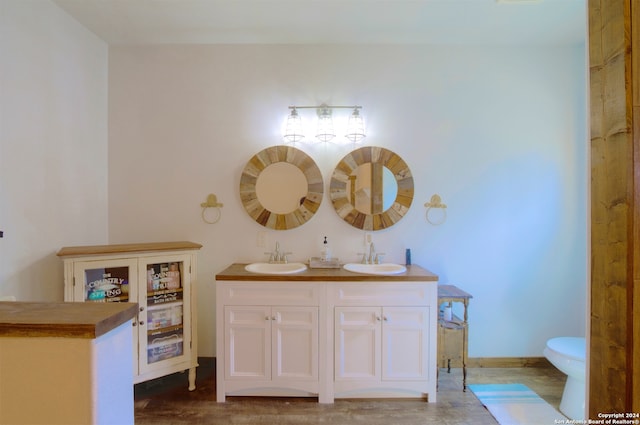 bathroom featuring toilet, hardwood / wood-style floors, and vanity