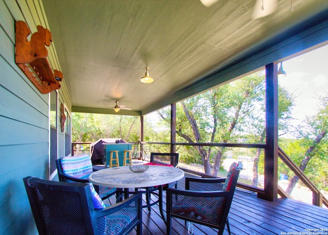 sunroom / solarium featuring a healthy amount of sunlight and ceiling fan