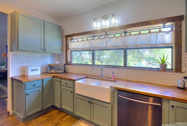 kitchen featuring stainless steel dishwasher, a healthy amount of sunlight, and wood counters