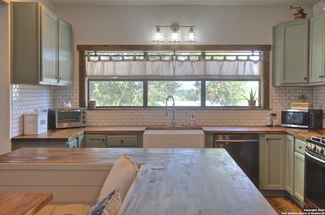 kitchen featuring sink, decorative backsplash, stainless steel appliances, and wood counters