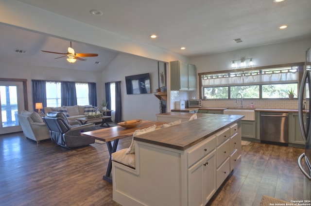 kitchen featuring sink, dishwasher, a kitchen island, dark hardwood / wood-style flooring, and decorative backsplash