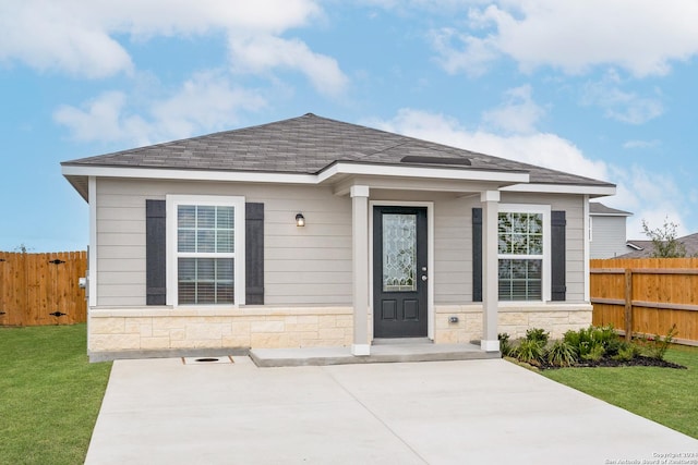 view of front of home with a patio and a front lawn